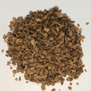 May include: A pile of brown, dried, and chopped root bark.