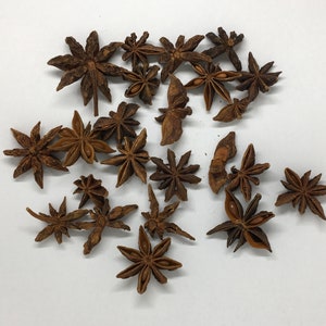 May include: A collection of dried star anise pods, a popular spice used in Asian cuisine. The pods are brown and have a star shape with eight points.