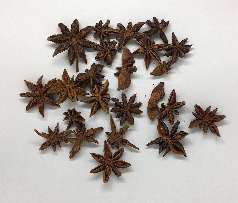 May include: A collection of dried star anise pods, a popular spice used in Asian cuisine. The pods are brown and have a star shape with eight points.