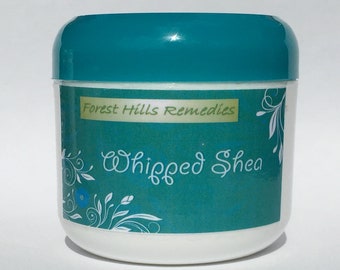 Puede incluir: Un tarro de color turquesa con una etiqueta blanca que dice "Forest Hills Remedies" y "Whipped Shea". La etiqueta tiene un diseño floral.