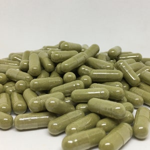 May include: A large pile of green capsules, likely a dietary supplement or herbal remedy.