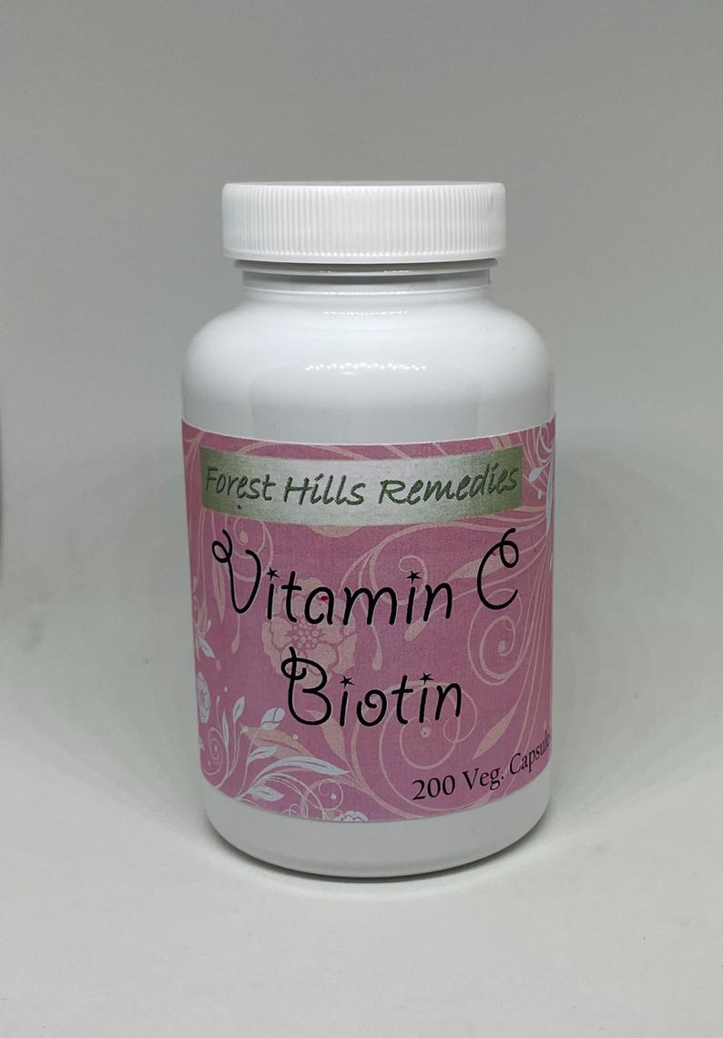 May include: A white plastic bottle with a white lid. The label is pink with the words "Vitamin C Biotin" and "Forest Hills Remedies". The bottle contains 200 capsules.