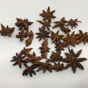 May include: A collection of dried star anise pods, a popular spice used in Asian cuisine. The pods are brown and have a star shape with eight points.