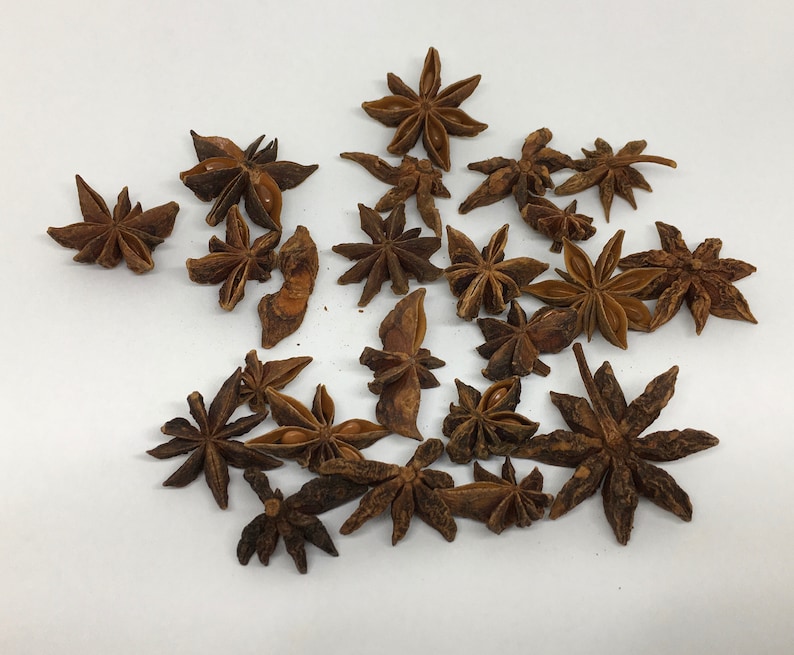 May include: A collection of dried star anise pods, a popular spice used in Asian cuisine. The pods are brown and have a star shape with eight points.