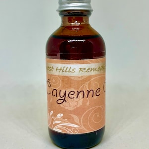 May include: A brown glass bottle with a silver lid. The bottle has a label that says "Forest Hills Remedies" and "Cayenne Oil".