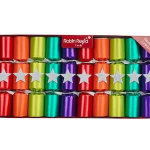 May include: A box of ten handmade crackers in a variety of bright colors, including red, orange, green, and purple. Each cracker is tied with a silver ribbon and adorned with a silver glitter star. The box is red and has the text "Robin Reed" and "10 Handmade Crackers".