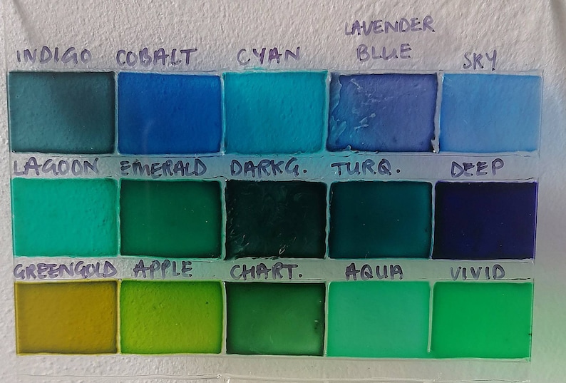 May include: A color chart with 16 paint swatches labeled with names like Indigo, Cobalt, Cyan, Lavender Blue, Sky, Lagoon, Emerald, Darkg. Turq., Deep, Greengold, Apple, Chart., Aqua, and Vivid.