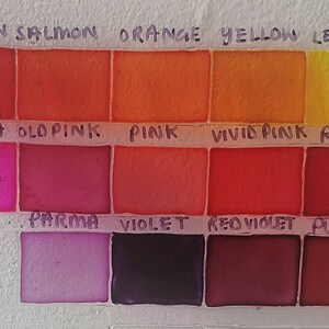 May include: A color chart with 12 paint swatches labeled with the names of the colors: Crimson, Salmon, Orange, Yellow, Lemon, Fuschia, Old Pink, Pink, Vivid Pink, Red, Parma, Violet, Red Violet, and Purple.