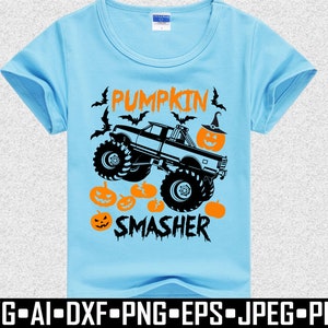 May include: Light blue t-shirt with a Halloween-themed graphic. The design features a monster truck with the text "PUMPKIN SMASHER", pumpkins, and bats. The shirt is made of a soft material.