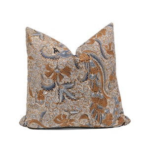 Op de afbeelding: Vierkant decoratief kussen met een gedetailleerd bloemmotief in bruin, blauw en wit. Het kussen heeft een complex ontwerp met wervelende lijnen en botanische elementen, waardoor een textuur ontstaat. Een decoratief woonaccessoire.