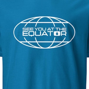 May include: A turquoise blue t-shirt with a white graphic of a globe with the text "See you at the Equator" inside.