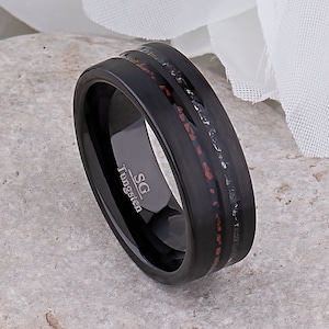 Op de afbeelding: Zwarte ring van wolfraamcarbide met een rode en zwarte inlay. De ring is gegraveerd met "SG Tungsten".