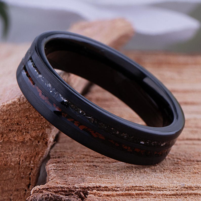 May include: A black tungsten carbide ring with a brown and silver inlay. The ring has a polished finish.