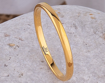May include: A simple gold wedding band with a smooth, rounded surface. The band is inscribed with "SG Titanium".