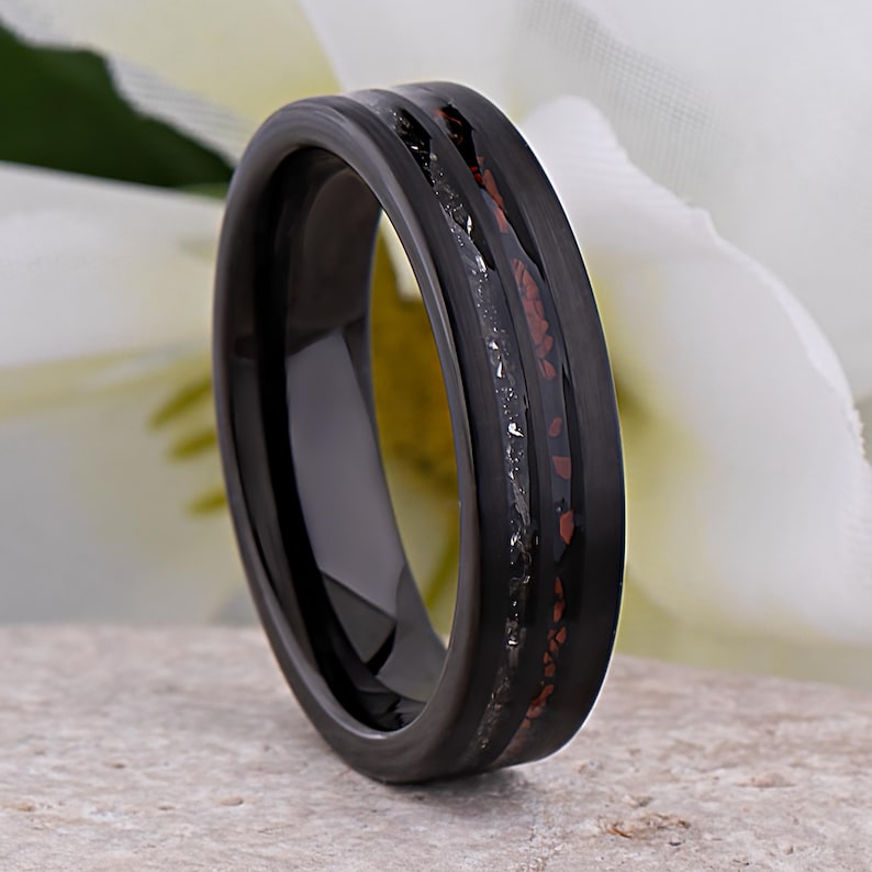 May include: Black tungsten carbide ring with a thin red and black inlay. The ring has a polished finish.