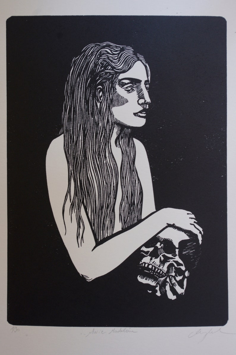 Puede incluir: Grabado en lin&oacute;leo en blanco y negro que representa a una mujer con pelo largo sosteniendo una calavera. La obra est&aacute; firmada y numerada 1/30. La impresi&oacute;n tiene un estilo minimalista con alto contraste.