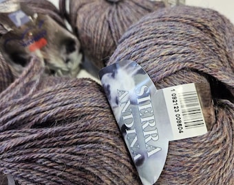 May include: A skein of Sierra Andina yarn in a dark purple and brown colorway. The yarn is labeled with the brand name and a barcode.