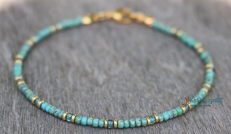 May include: A delicate turquoise and gold beaded necklace. The necklace is made with small, round turquoise beads and gold spacers.