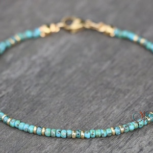 May include: A delicate turquoise and gold beaded bracelet. The bracelet is made with small, round turquoise beads and gold spacers. The bracelet is approximately 7 inches in length and has a lobster clasp closure.