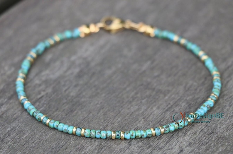 May include: A delicate turquoise and gold beaded bracelet. The bracelet is made with small, round turquoise beads and gold spacers. The bracelet is approximately 7 inches in length and has a lobster clasp closure.