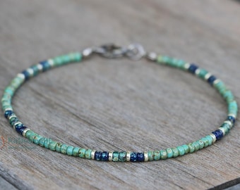 Könnte beinhalten: Ein türkisfarbenes und blaues Armband mit einem silbernen Verschluss.