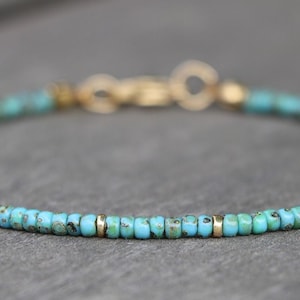 K&ouml;nnte beinhalten: Ein zartes Armband aus T&uuml;rkis und Gold. Das Armband besteht aus kleinen, runden T&uuml;rkisperlen und goldenen Zwischenst&uuml;cken.