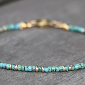May include: A delicate turquoise and gold beaded bracelet. The bracelet is made with small, round turquoise beads and gold spacers.