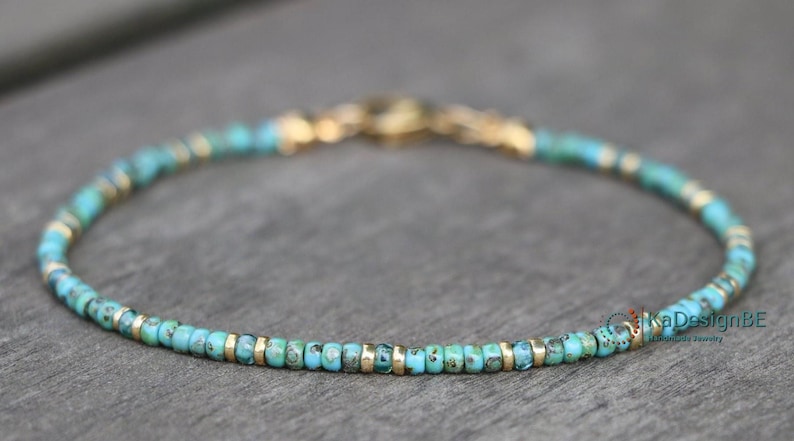 May include: A delicate turquoise and gold beaded bracelet. The bracelet is made with small, round turquoise beads and gold spacers.