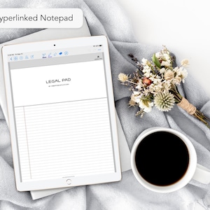 May include: A white tablet computer with a legal pad app open on the screen. The app has a gray header with the text "LEGAL PAD" and the words "by codanotes.com". The tablet is on a gray blanket with a small bouquet of dried flowers and a white coffee mug.