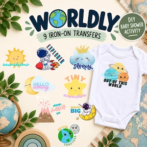 Op de afbeelding: Een set van negen opstrijkbare transfers met ruimte-thema illustraties, waaronder planeten, een astronaut, een zon, een ster en een vulkaan, met teksten zoals "WORLDLY", "EXPLORER", "sleepy", "OUT OF THIS WORLD", "HELLO darling", "TINY wonder", "always LAVA you", "DREAM BIG" en "BETTER TOGETHER".