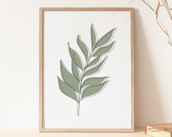 Könnte beinhalten: Ein gerahmter Druck eines minimalistischen Strichzeichnung eines grünen Blattes auf weißem Hintergrund. Der Rahmen ist aus hellem Holz und der Druck liegt auf einer beigefarbenen Oberfläche.