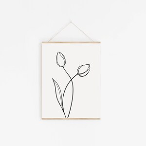 Puede incluir: Un dibujo en blanco y negro de dos tulipes con tallos y hojas sobre un fondo blanco.