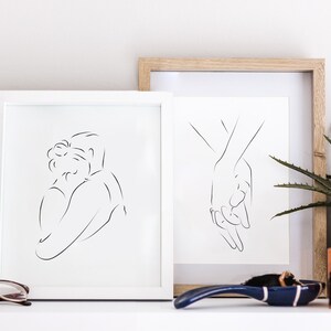 May include: Two framed black and white line drawings of couples. The first drawing shows a couple embracing, while the second drawing shows two hands holding each other.