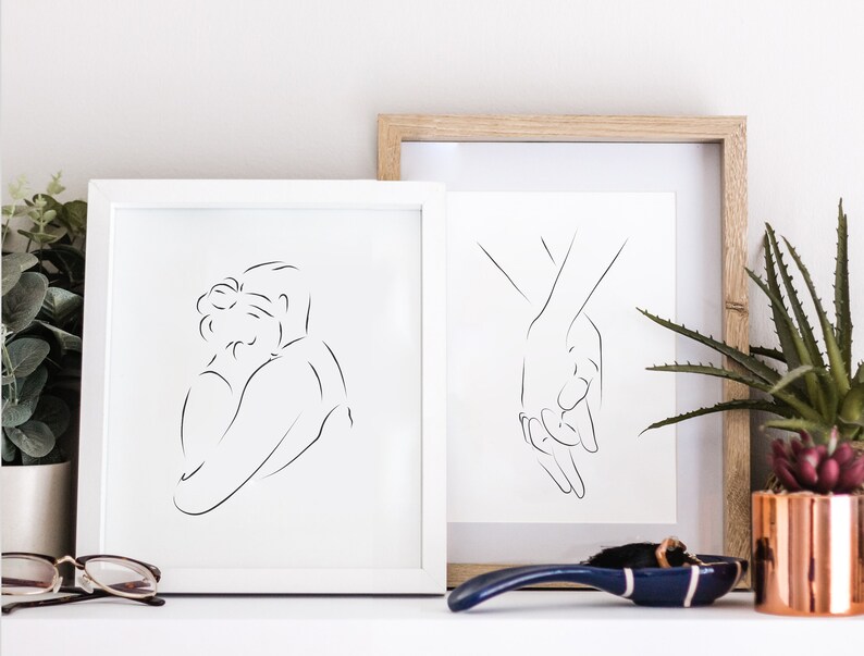 May include: Two framed black and white line drawings of couples. The first drawing shows a couple embracing, while the second drawing shows two hands holding each other.