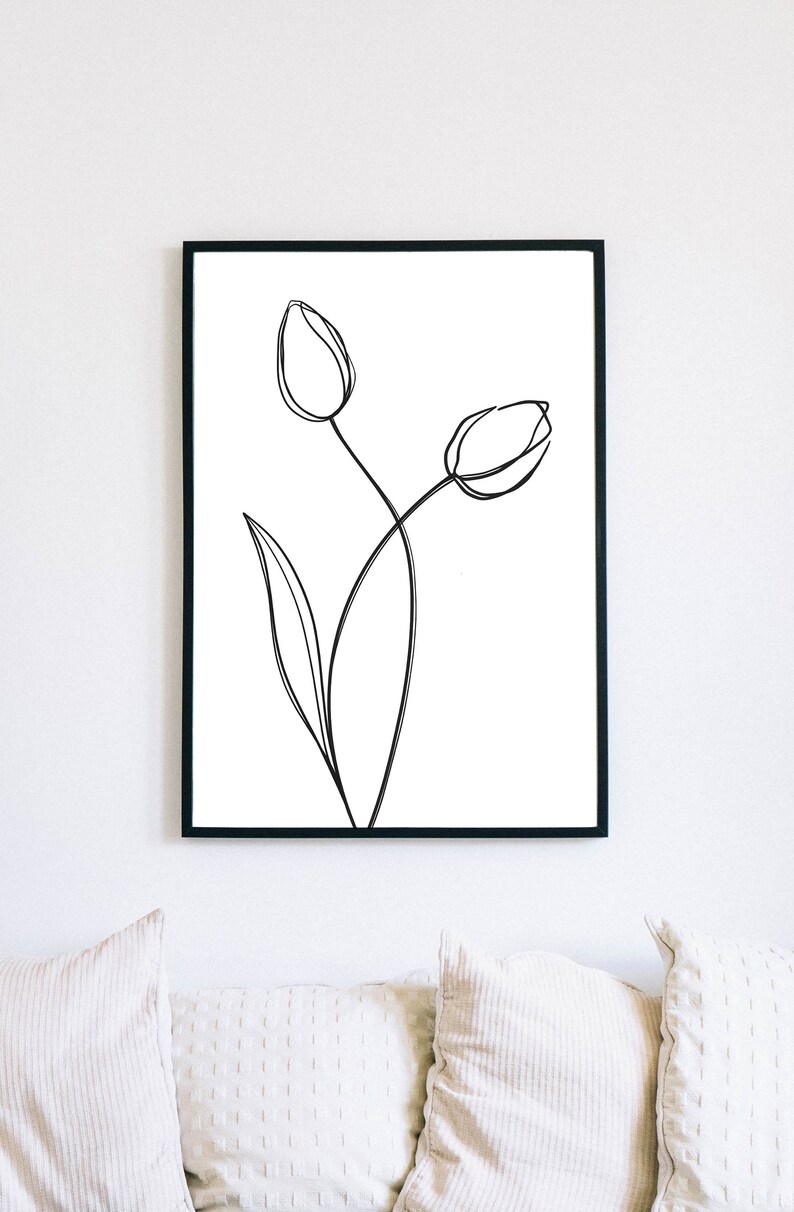 Puede incluir: Un dibujo en blanco y negro de dos tulipanes en un estilo simple y minimalista. El dibujo est&aacute; enmarcado en un marco negro y cuelga de una pared blanca.