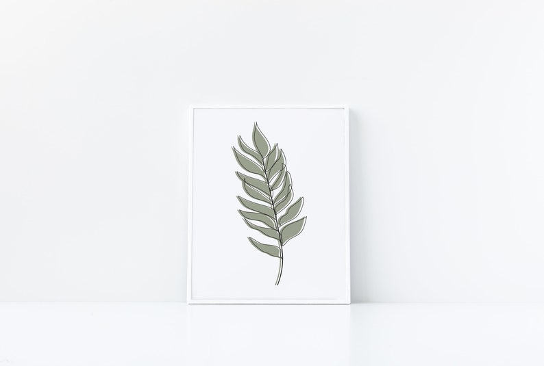 May include: A framed print of a minimalist line drawing of a green leaf on a white background.