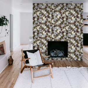 May include: A fireplace surround with a mosaic of brown, beige, and gray round tiles. The fireplace is in a living room with a wooden chair and a white rug.