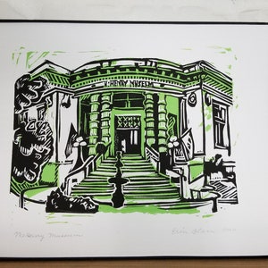May include: A black and green linocut print of the Henry Museum. The print features a building with a large entrance and steps leading up to it. The building has a sign that reads "Henry Museum".
