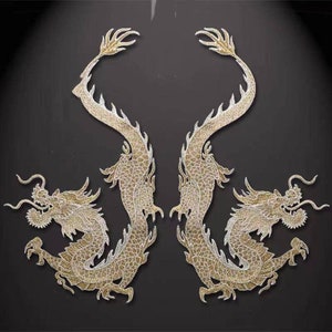 May include: Two gold embroidered dragon appliques with intricate details. The dragons are facing each other with their tails intertwined.