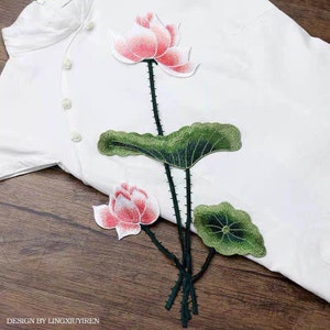May include: Embroidered patch featuring a pink and white lotus flower with green leaves. The patch is perfect for adding a touch of nature to clothing, bags, or other crafts.