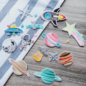 Puede incluir: Un conjunto de 12 parches para planchar con temática espacial. Los parches incluyen un cohete, planetas, estrellas, un OVNI, un astronauta y una luna. Los parches son coloridos y tienen una variedad de diseños.