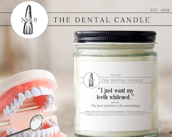 May include: A glass jar candle with a black lid, labeled "The Dental Candle." The label includes the text "I just want my teeth whitened." and a tooth graphic. A dental model and mirror are in the foreground. The candle is 8 oz.
