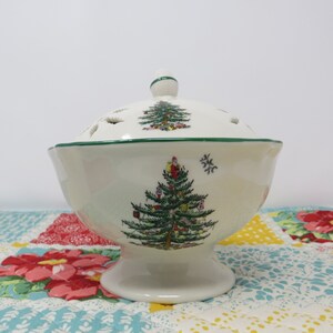 May include: White ceramic bowl with a green and white Christmas tree design. The bowl has a lid with holes and sits on a pedestal base.
