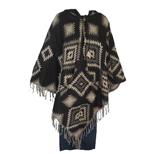 May include: Black and white geometric patterned hooded poncho with fringe trim.