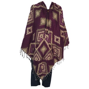May include: A purple and beige hooded poncho with a geometric pattern. The poncho has a button closure and two pockets.