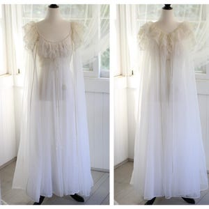 Peut inclure: Une chemise de nuit longue et transparente de couleur blanche, dotée d'une encolure dégagée, de manches courtes à volants en dentelle et d'une jupe fluide. Le vêtement présente un lien de serrage délicat et de longs pans transparents.
