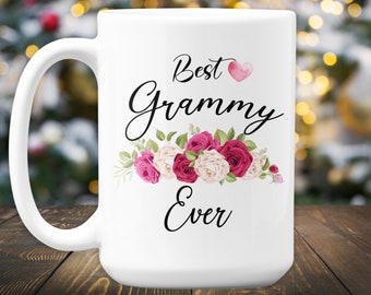 May include: White ceramic coffee mug with a black design that says "Best Grammy Ever" with a pink heart and a floral design of pink and white roses.