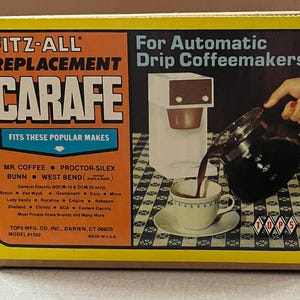 May include: A yellow box with the text "FITZ-ALL REPLACEMENT CARAFE" for automatic drip coffeemakers. The box features an illustration of a coffee maker pouring coffee into a cup. Fits popular brands like Mr. Coffee and Bunn.