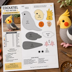 Könnte beinhalten: Ein digitales PDF-Schnittmuster für einen Nymphensittich aus Filz, bestehend aus einer gedruckten Anleitung mit Diagrammen, einem fertigen Filz-Nymphensittich, Stickgarn, einer goldenen Schere und einer kleinen Schale mit Stecknadeln auf Holz.