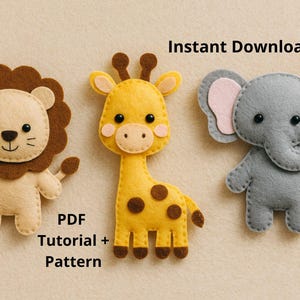 May include: Three felt animal figures: a lion, a giraffe, and an elephant. The lion is tan with a brown mane, the giraffe is yellow with brown spots, and the elephant is grey with pink ears. Text reads "Instant Download" and "PDF Tutorial + Pattern".